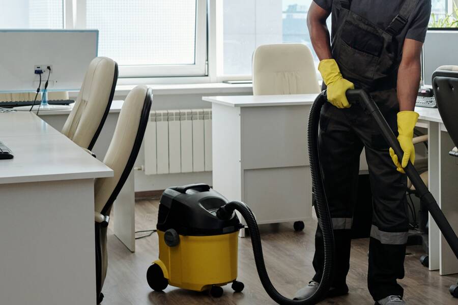 Vacuuming between desks in an open-plan office